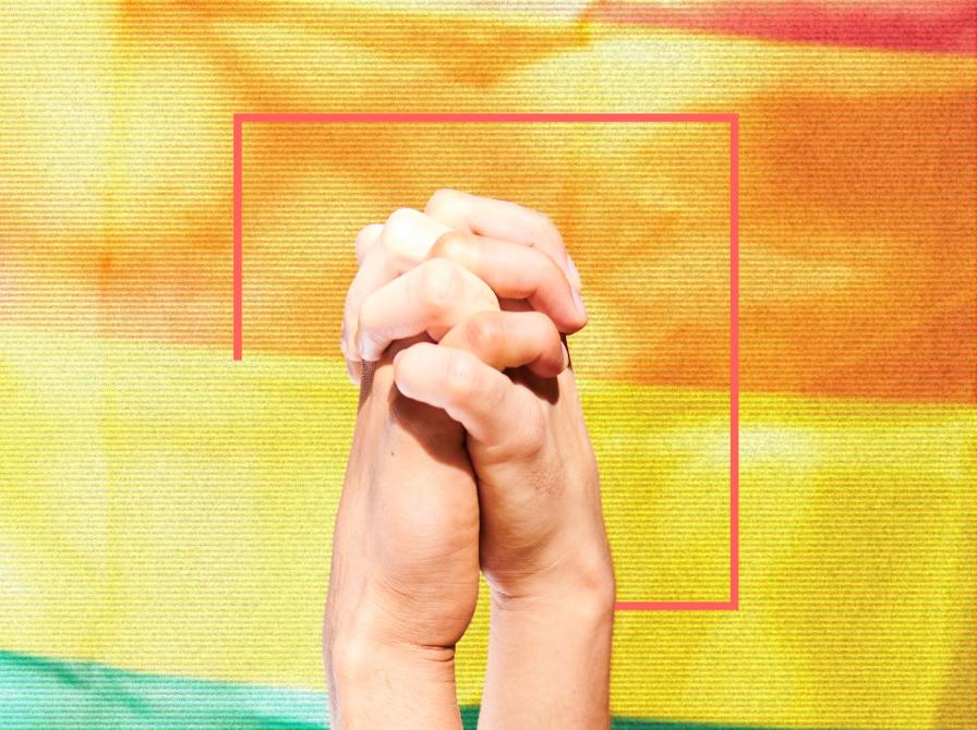 To hænder flettet sammen foran en regnbuefarvet baggrund.